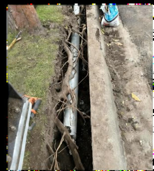 Narrow trench beside a kerb with exposed services