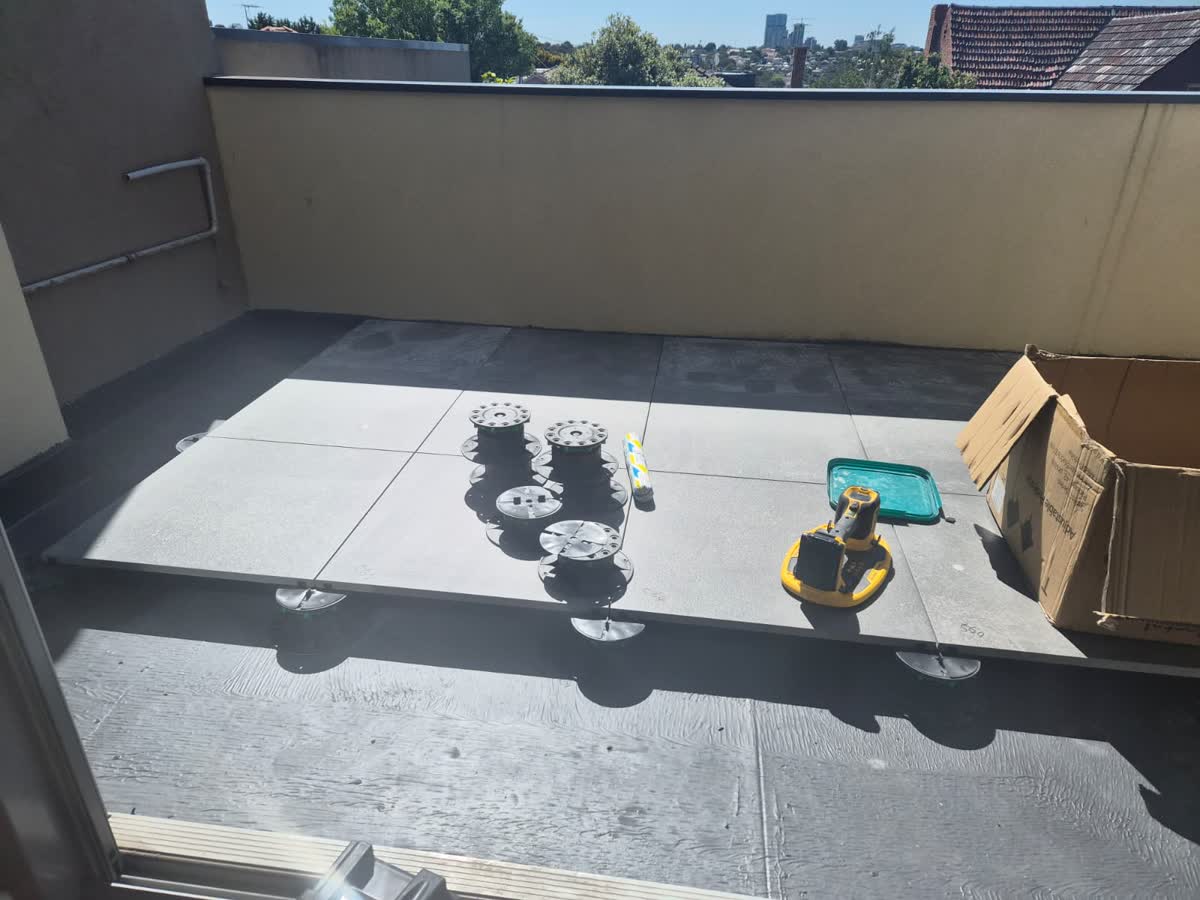 Balcony floor with large tiles being laid on pedestals
