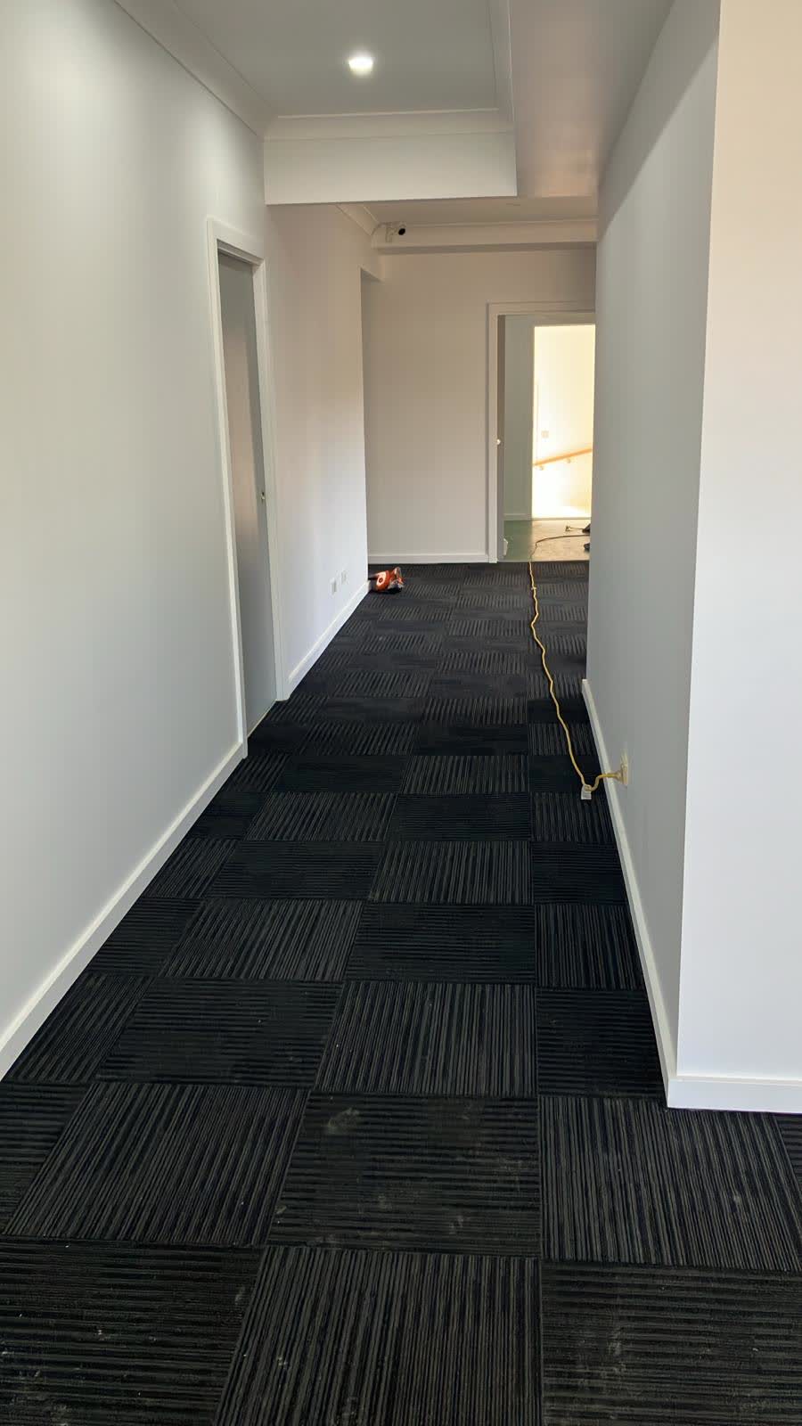 Corridor with white walls and black carpet tiles