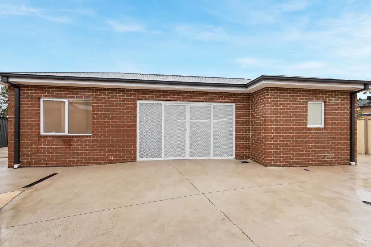 Single-storey brick granny flat with a sliding door and a new concrete yard