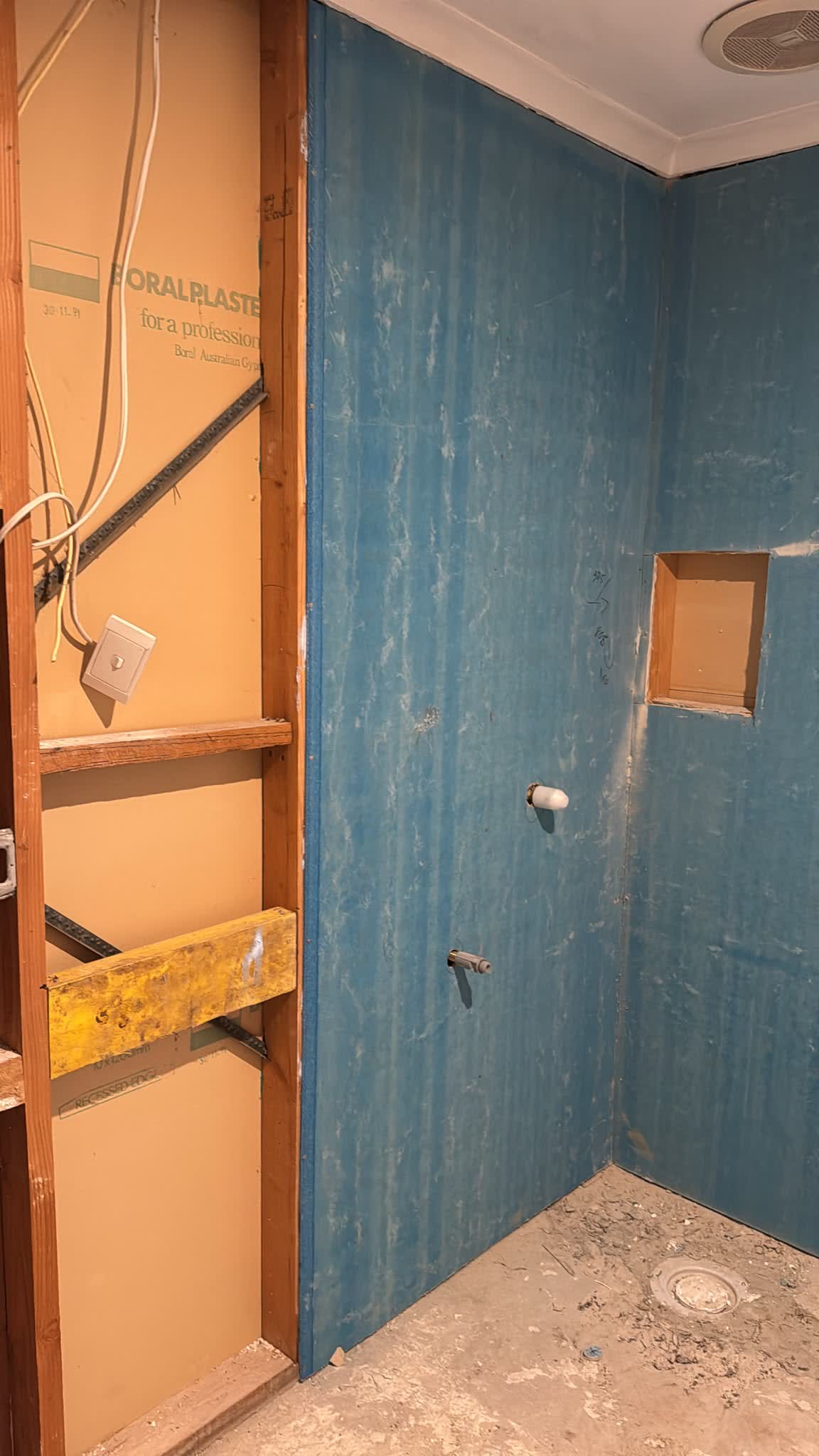 Bathroom wall sheeted and waterproofed, with a shower niche
