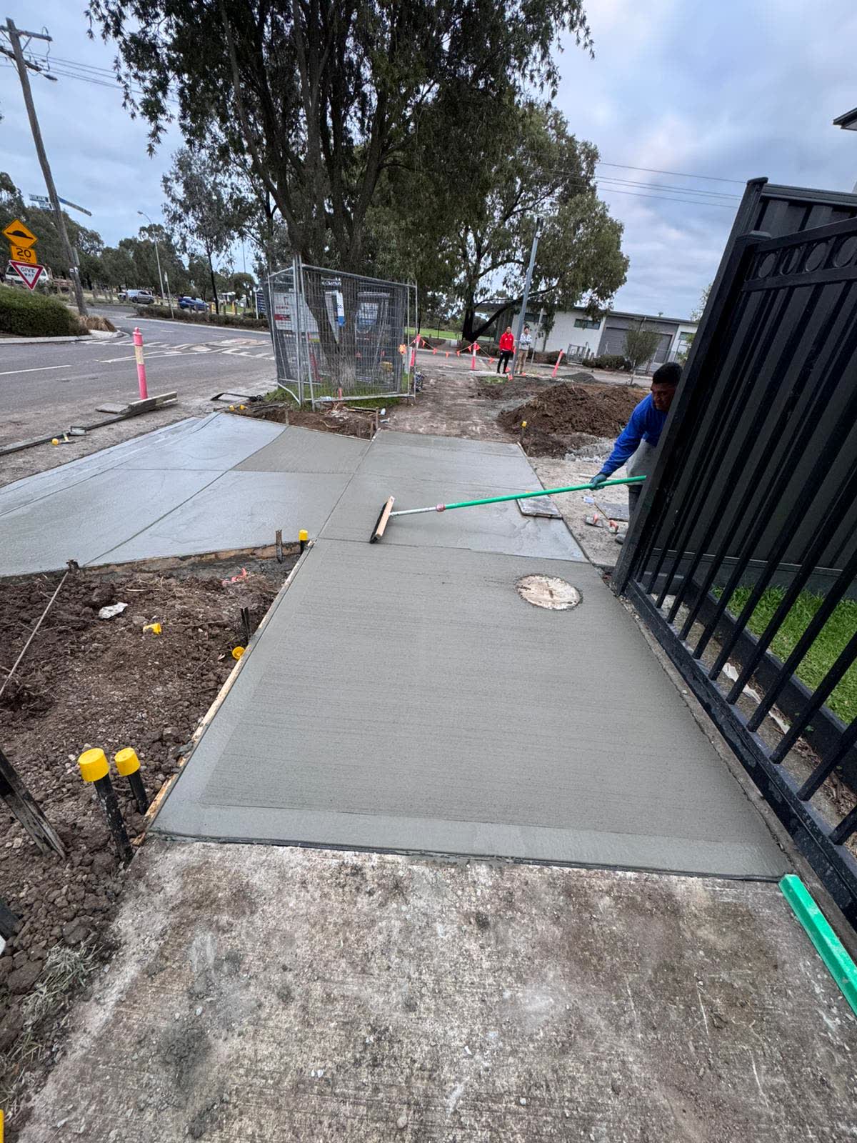 Fresh concrete path being finished beside the townhouses