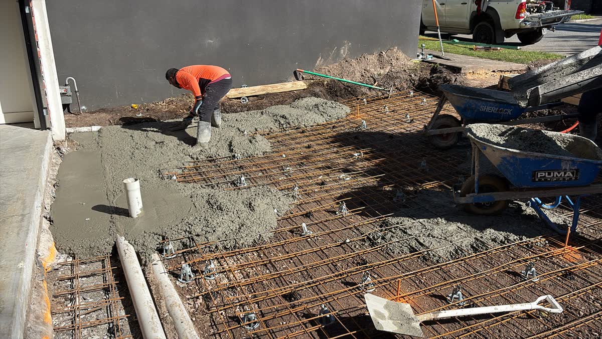 Reinforcing mesh and fresh concrete being placed around the turntable base