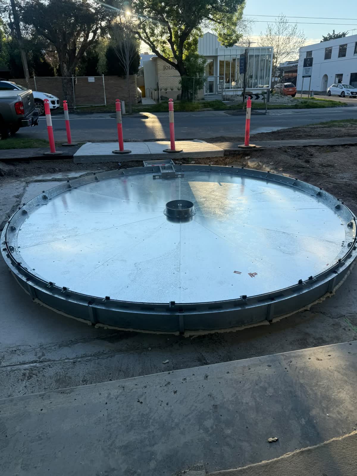 Round steel turntable plate set into its base beside the street